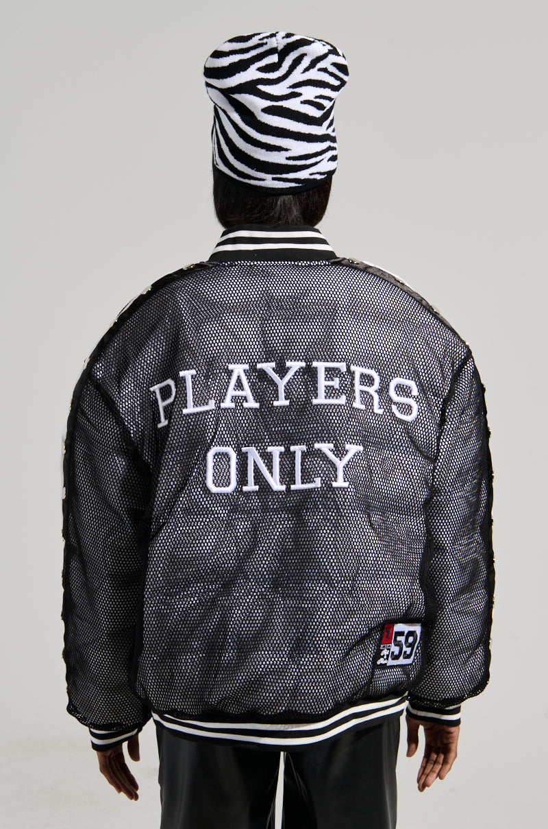 A person wears a PLAYERS ONLY JERSEY BOMBER in black and white, featuring "PLAYERS ONLY" on the back. They pair it with a matching zebra-striped hat and face away from the camera, highlighting an athletic patch at the jacket's hem.