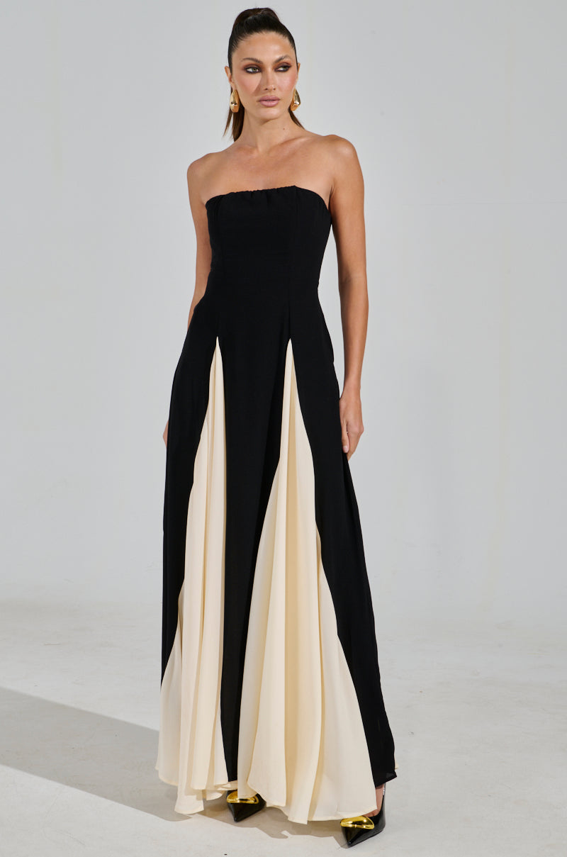 A woman poses confidently against a plain background, her hair pulled back, wearing the strapless ON MY FYP CHIFFON MAXI DRESS in black with white pleats.