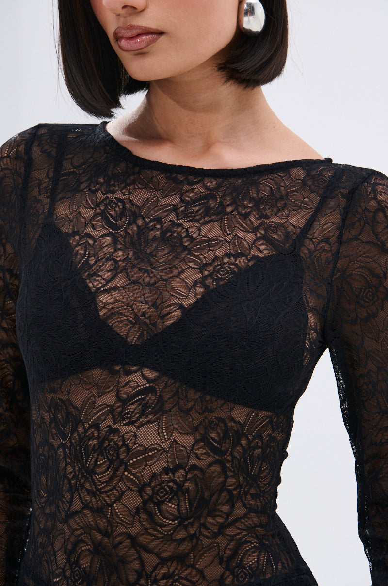 Woman wearing the ONLY IF THERE'S BOTTLE SERVICE LACE JUMPSUIT, a sheer, curve-hugging black floral lace design over a black lace bra, with large silver hoop earrings and a bob haircut. Image is cropped from shoulders to waist.