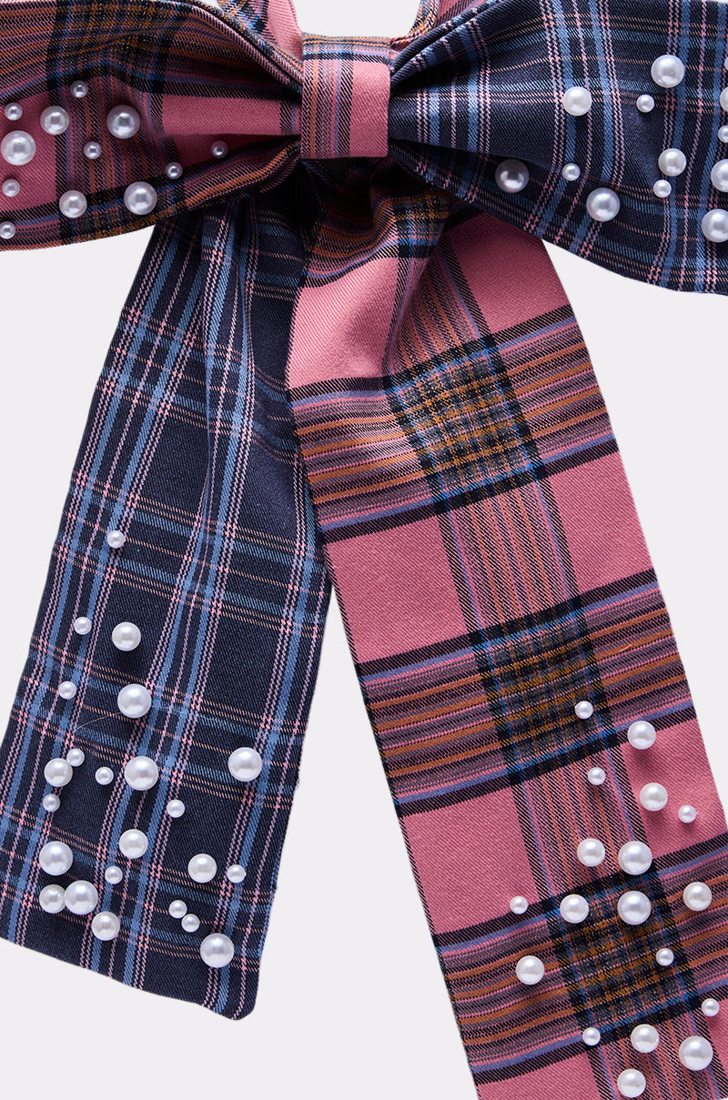 The DREKE OVER THE TOP BOW NECKLACE features a plaid bow in pink, navy, and white stripes, accented with scattered white pearl-like beads for a bold statement accessory.