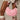 A white lace dress and pink boots outfit is accessorized with the BOWTIFUL PURSE, adorned with baby pink bows. Knee-high ribbed socks complete the look, while the top handle bag dangles elegantly from a hand against a neutral background.