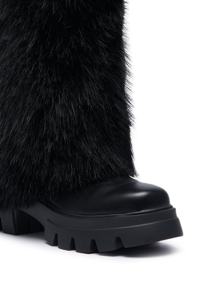 Close-up of the AZALEA WANG ASHOKA BLACK FUZZY FLATFORM MID CALF BOOT showcasing its stylish black, mid-calf design with a textured, furry outer layer and a chunky, ribbed sole. The boot's sleek design and rugged sole create a striking contrast, highlighting its unique and modern aesthetic.