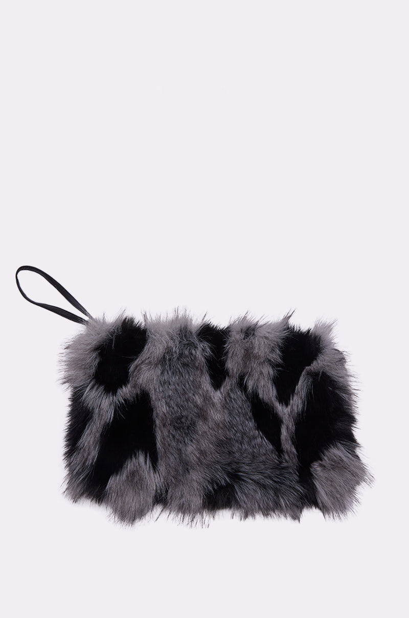 The ARLO FAUX FUR WRISTLET is a chic rectangular clutch with a black strap, featuring soft, two-tone black and gray faux fur. Shown against a light background, it’s a stylish plush accessory for any occasion.