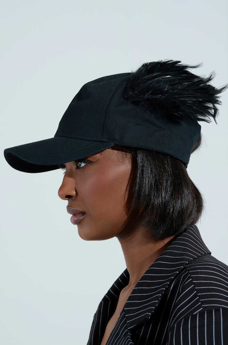 Side profile of a person wearing a black feathered BRB FLYING AWAY HAT with an adjustable back strap for the perfect fit, paired with a black pinstripe shirt. The background is light gray.