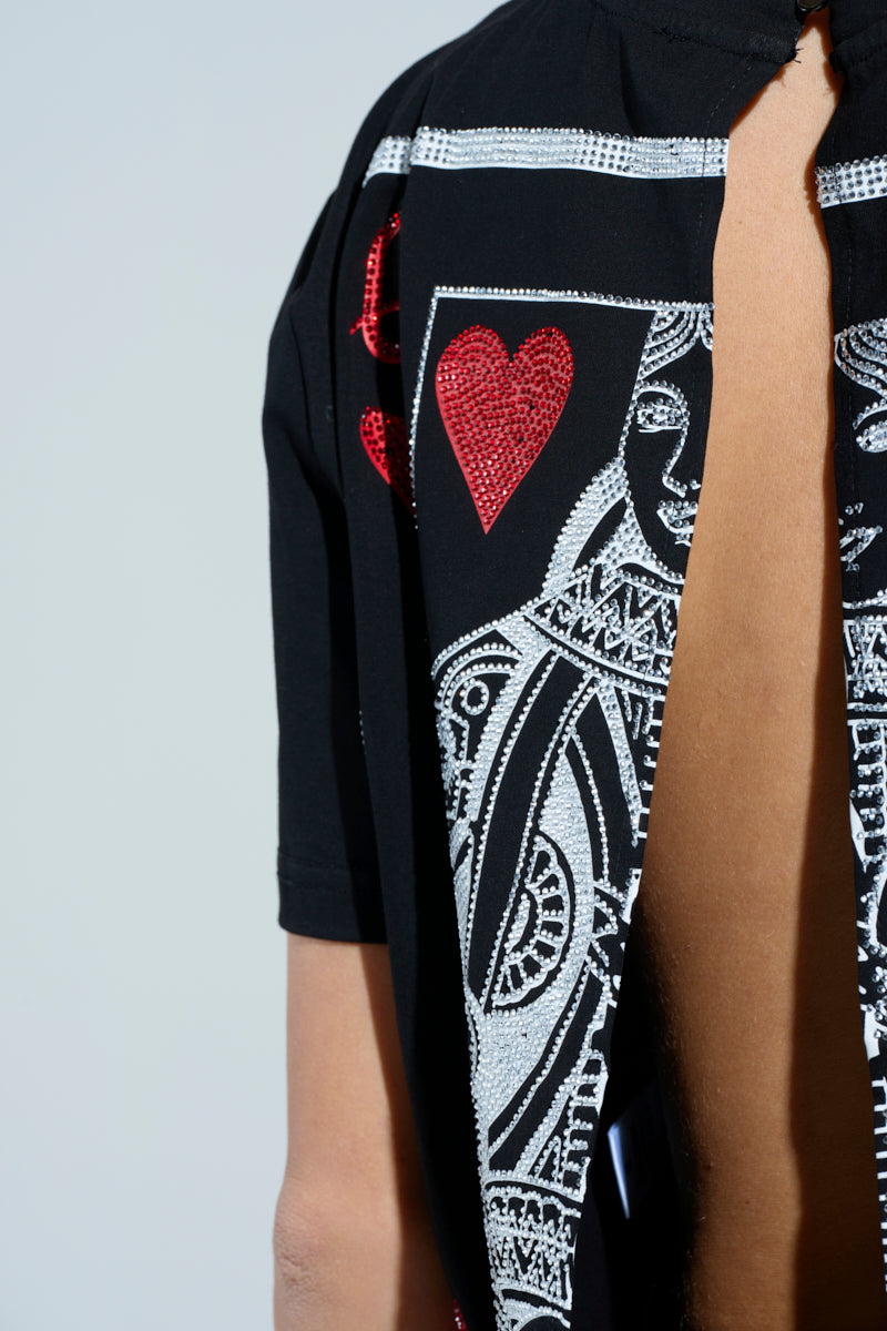 A close-up of the black LUCKY WINNER T-SHIRT showcases the queen of hearts design with red hearts, intricate white details, a partially open back revealing skin, and rhinestone embellishments adding flair.