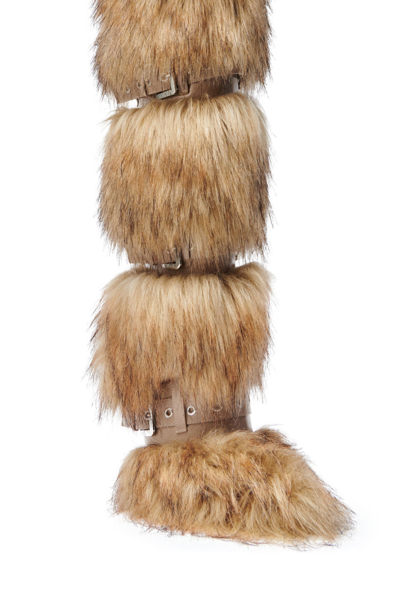 A close-up side view of the AZALEA WANG AMALBERT Brown Multi Fur and Buckles Boot, featuring knee-high layered light brown faux fur with buckles and straps, designed to resemble an animal's leg.