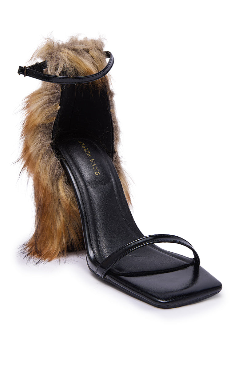 The AZALEA WANG ARETTE BLACK SANDAL features thin straps, a square toe, and a chunky heel wrapped in brown fur for a bold, fashion-forward look.