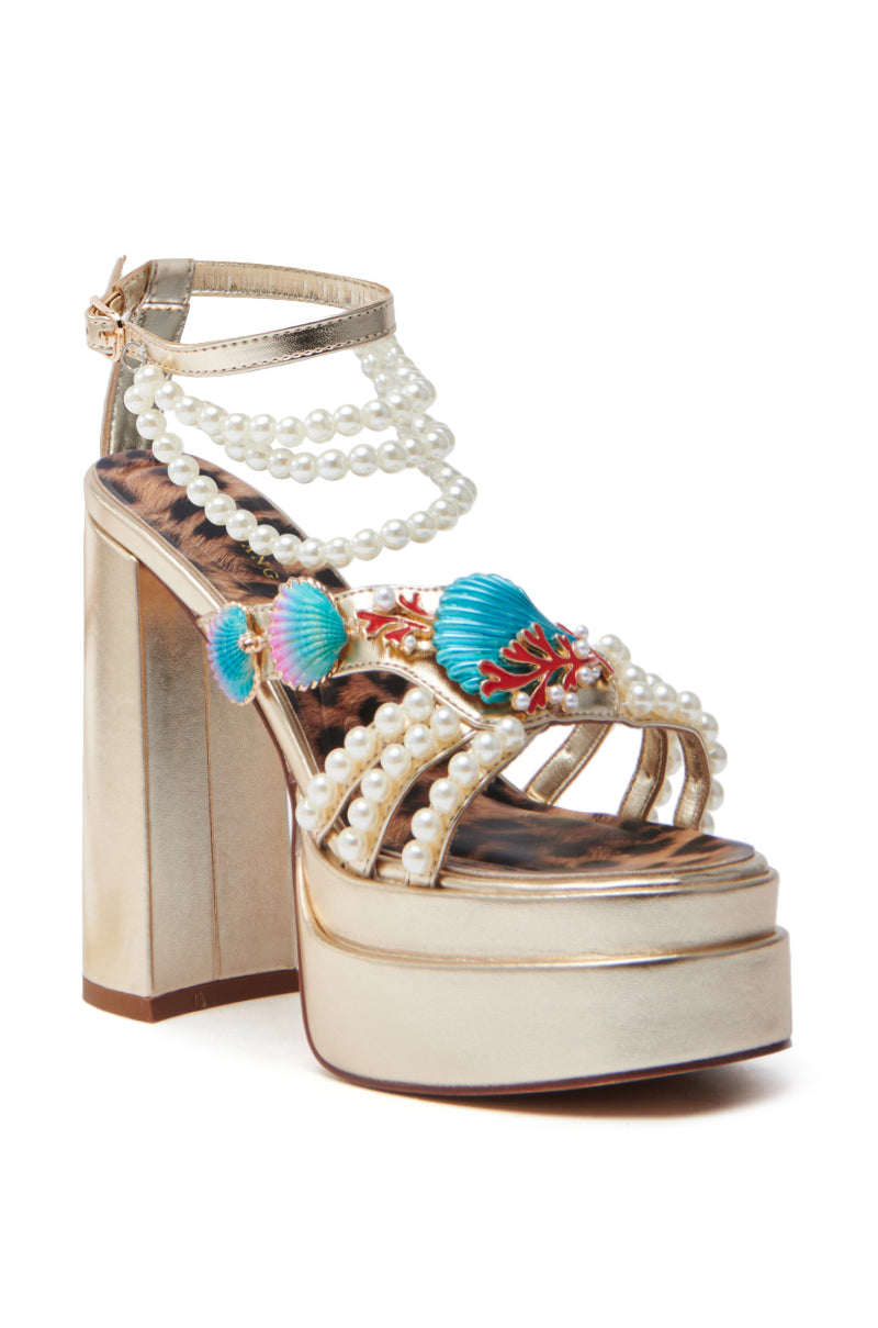 The AZALEA WANG ARLETH GOLD SANDAL sparkles with glittering straps featuring pearl-like beads, colorful shell accents, and a leopard print insole. An ankle strap with a small buckle and a chic, chunky heel elevate any outfit with flair.