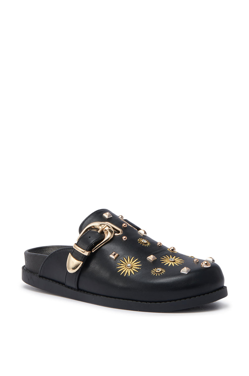 The AZALEA WANG TROUVER BLACK GOLD STARBURST FLAT is a black faux leather clog-style slip-on with gold studs, starburst embellishments, and a large gold buckle; part of the Trouver collection.