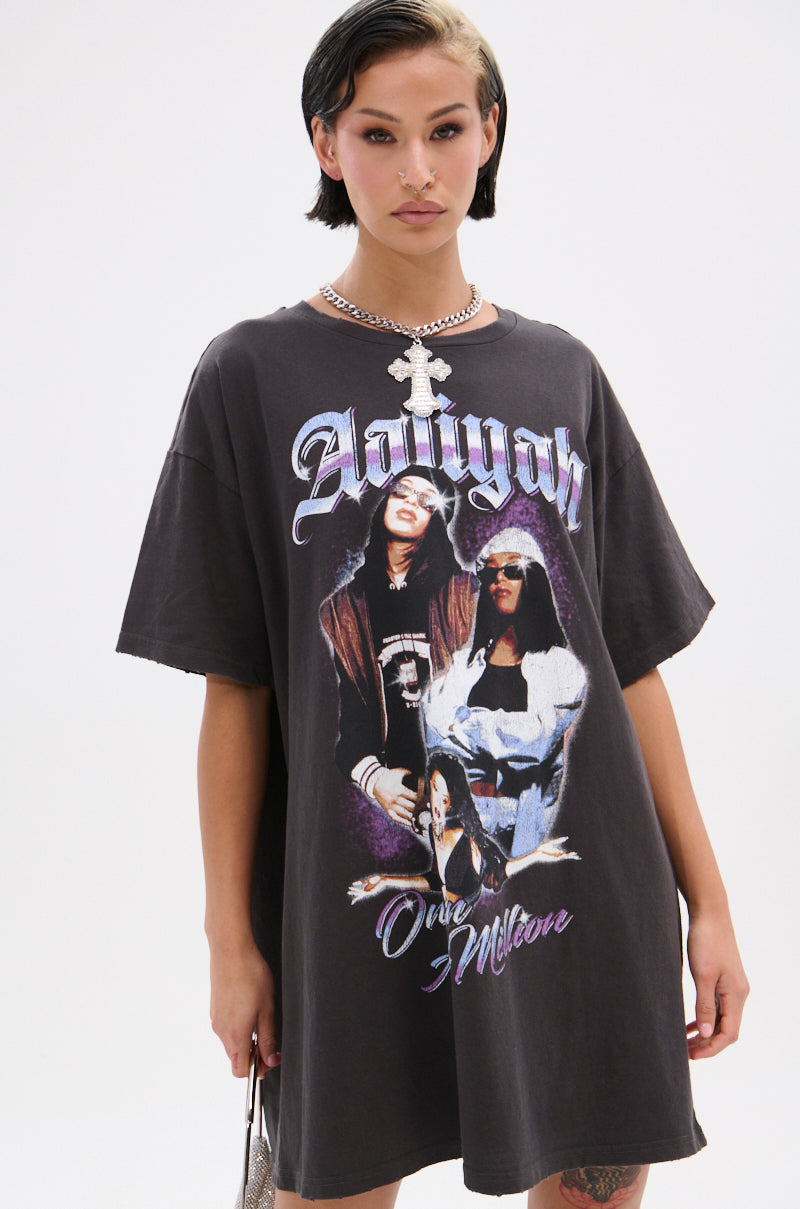 A person with short dark hair and a side blonde streak wears the AALIYAH FOREVER GRAPHIC TSHIRT DRESS, styled with a chunky silver chain necklace and cross pendant—a perfect tribute for any streetwear lineup.