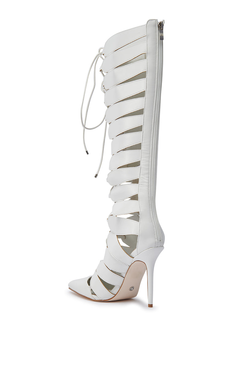 The AZALEA WANG BASTIAN WHITE BOOT is a knee-high, faux leather gladiator stiletto with horizontal straps, pointed toe, lace-up front, back zipper, and high stiletto heel, shown in profile on a white background.