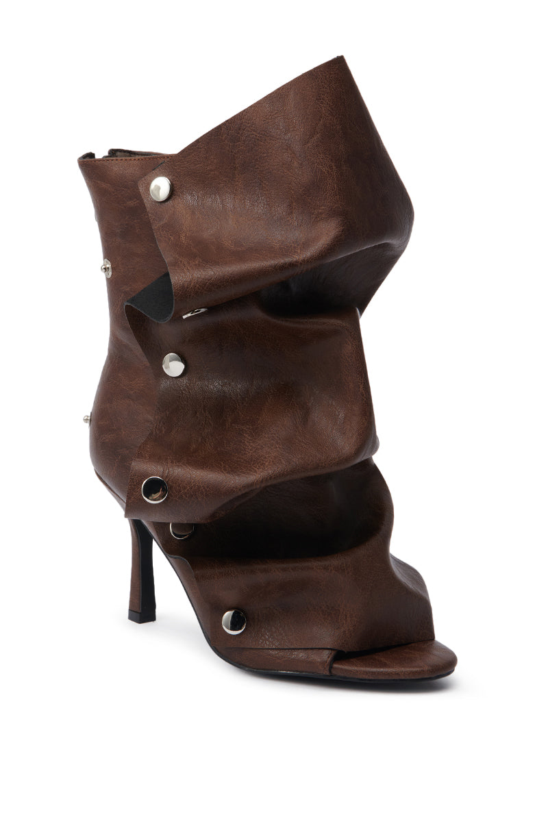 The AZALEA WANG BIRD SONG BROWN SNAP DETAIL OPEN TOE BOOTIE features brown faux leather, a high heel, layered and folded sculptural design, silver snap accents, and an avant-garde open toe look.