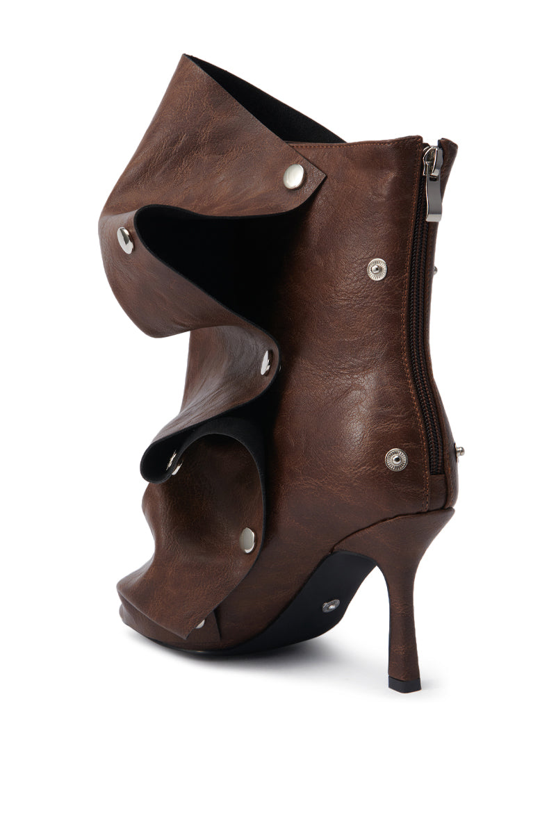 The AZALEA WANG BIRD SONG BROWN SNAP DETAIL OPEN TOE BOOTIE is a high-heeled ankle boot in dark brown faux leather with layered panels, silver-tone snap buttons, a side zipper, and a slim stiletto heel.