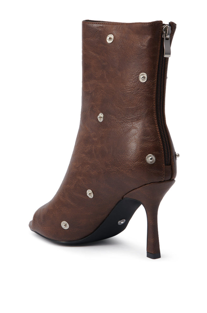 The AZALEA WANG BIRD SONG BROWN SNAP DETAIL OPEN TOE BOOTIE features a brown faux leather finish, side zipper, silver snap details, an open toe design, and a chic stiletto heel.