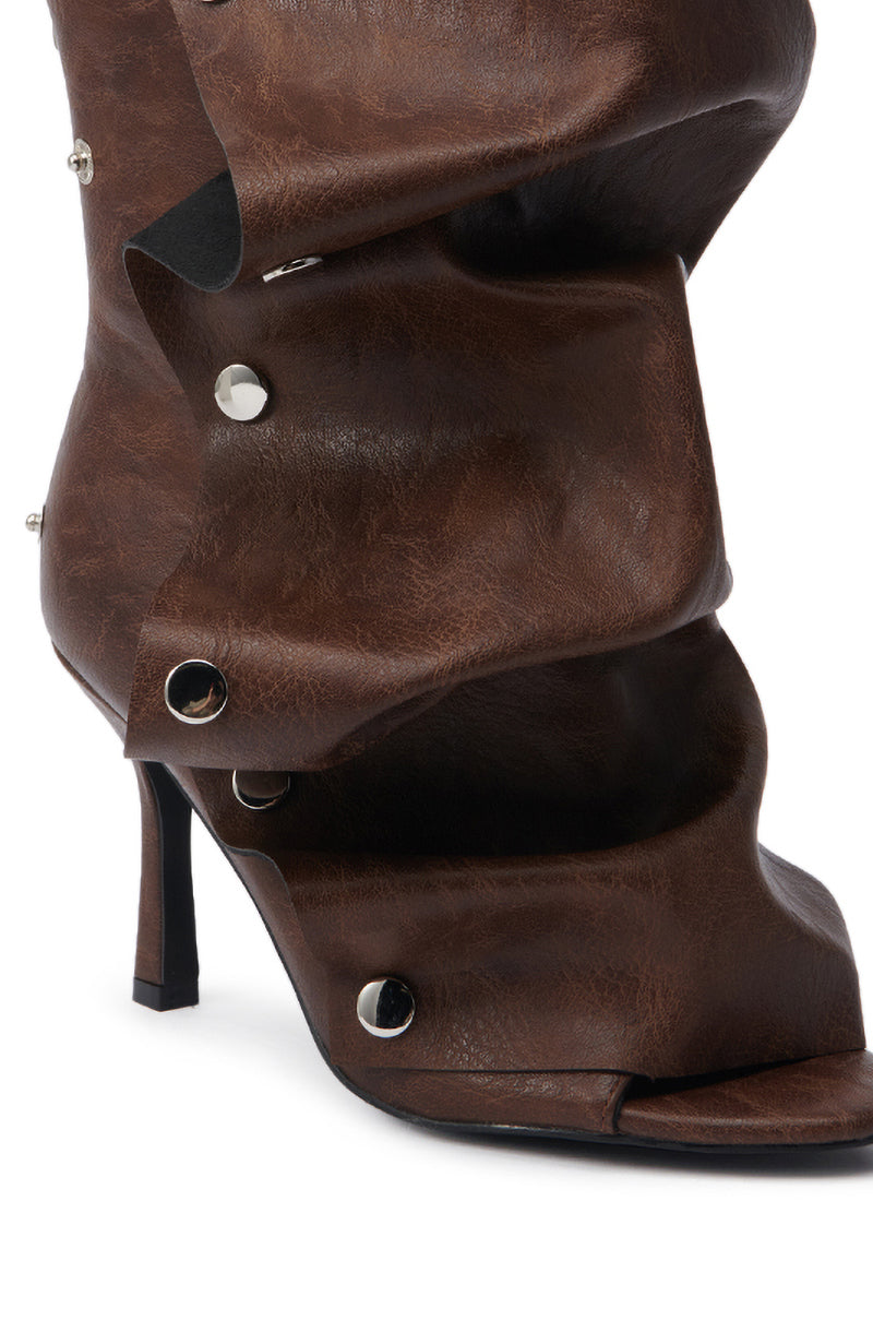 A close-up of the AZALEA WANG BIRD SONG BROWN SNAP DETAIL OPEN TOE BOOTIE, featuring an almond peep toe, high heel, dark brown ruched leather, shiny silver snap details, and a sculptural layered appearance.