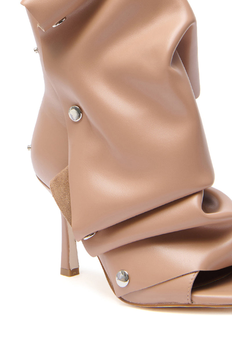 A close-up of the AZALEA WANG BIRDSONG SNAP OPEN-TOE BOOTIE IN MOCHA, a beige faux patent leather stiletto featuring a slouched, ruched design with metallic studs and an open-toe bootie silhouette.