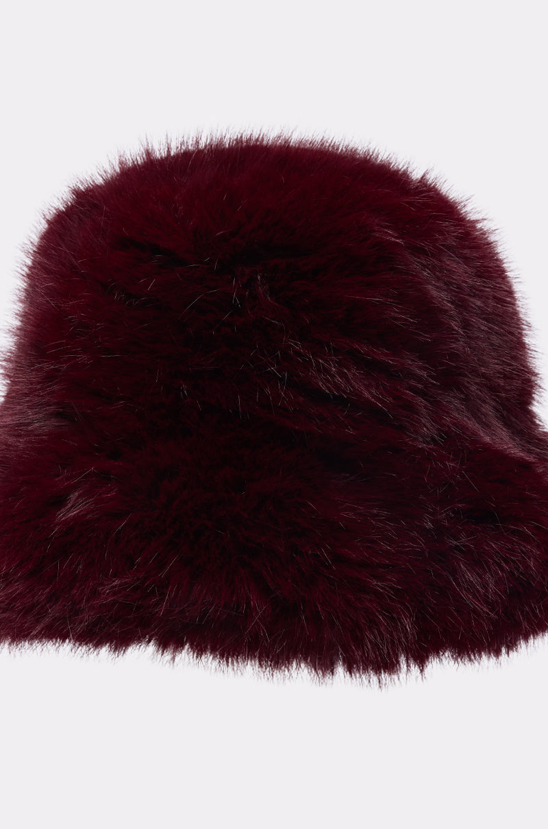 The ELEVATED FAUX FUR BUCKET HAT in dark burgundy features a plush, soft, and fluffy texture—ideal for enhancing your winter wardrobe. Shown on a plain white background.