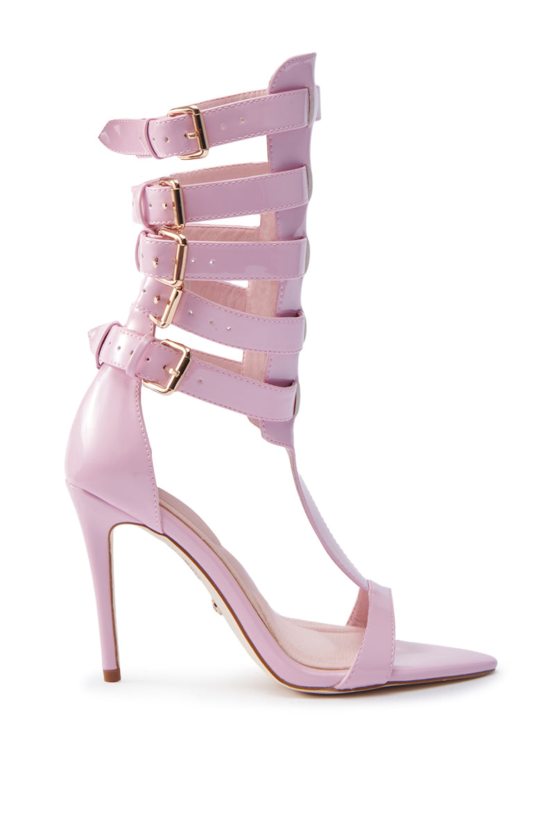 The AZALEA WANG CHERELL Pink Gladiator Sandal Stiletto features a pointed toe, multiple ankle straps with gold buckles, and is crafted in faux leather. Displayed on a white background, its sophisticated and stylish design is showcased elegantly.