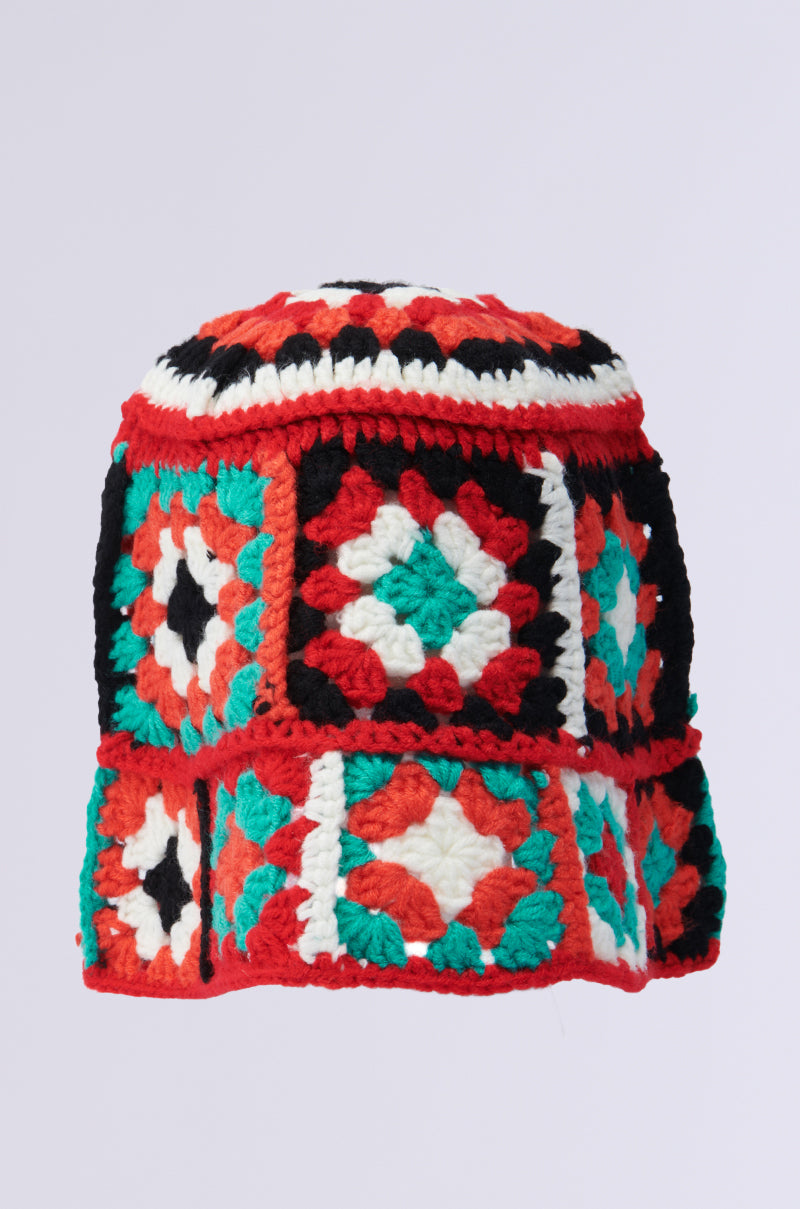 The CROCHET BUCKET HAT features colorful square patches in red, white, turquoise, black, and orange with geometric patterns. This vibrant design has a rounded shape and detailed stitching for a textured look.