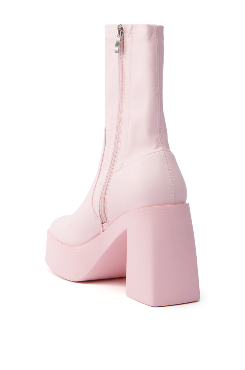 The AZALEA WANG Danielle Bootie in baby pink stretch PU features a chunky heel and smooth faux leather finish, complete with a side zipper for convenience. Styled to showcase the back and one side, it perfectly blends style with functionality.