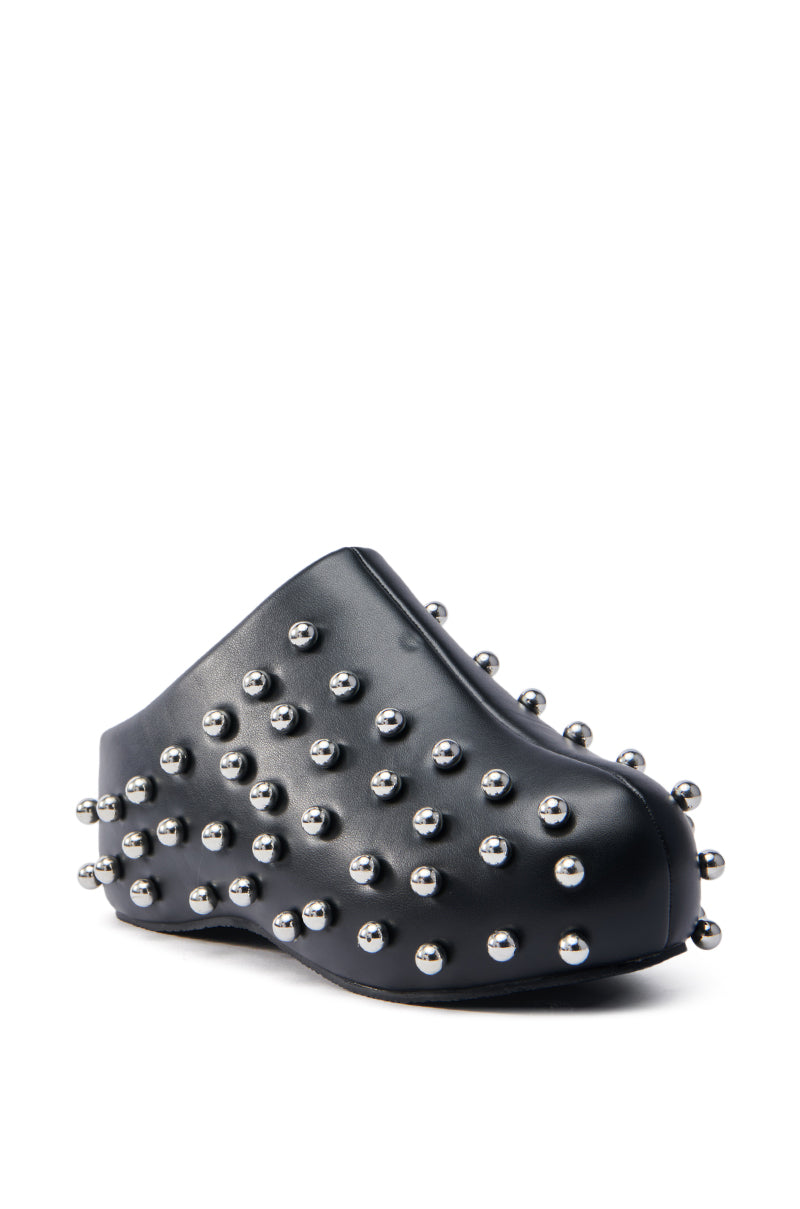 The AZALEA WANG DARWIN STUD FLAT CLOG IN BLACK, crafted from vegan leather, features a minimalist design with a flat sole and is adorned in evenly distributed small metallic spikes seen in close-up.