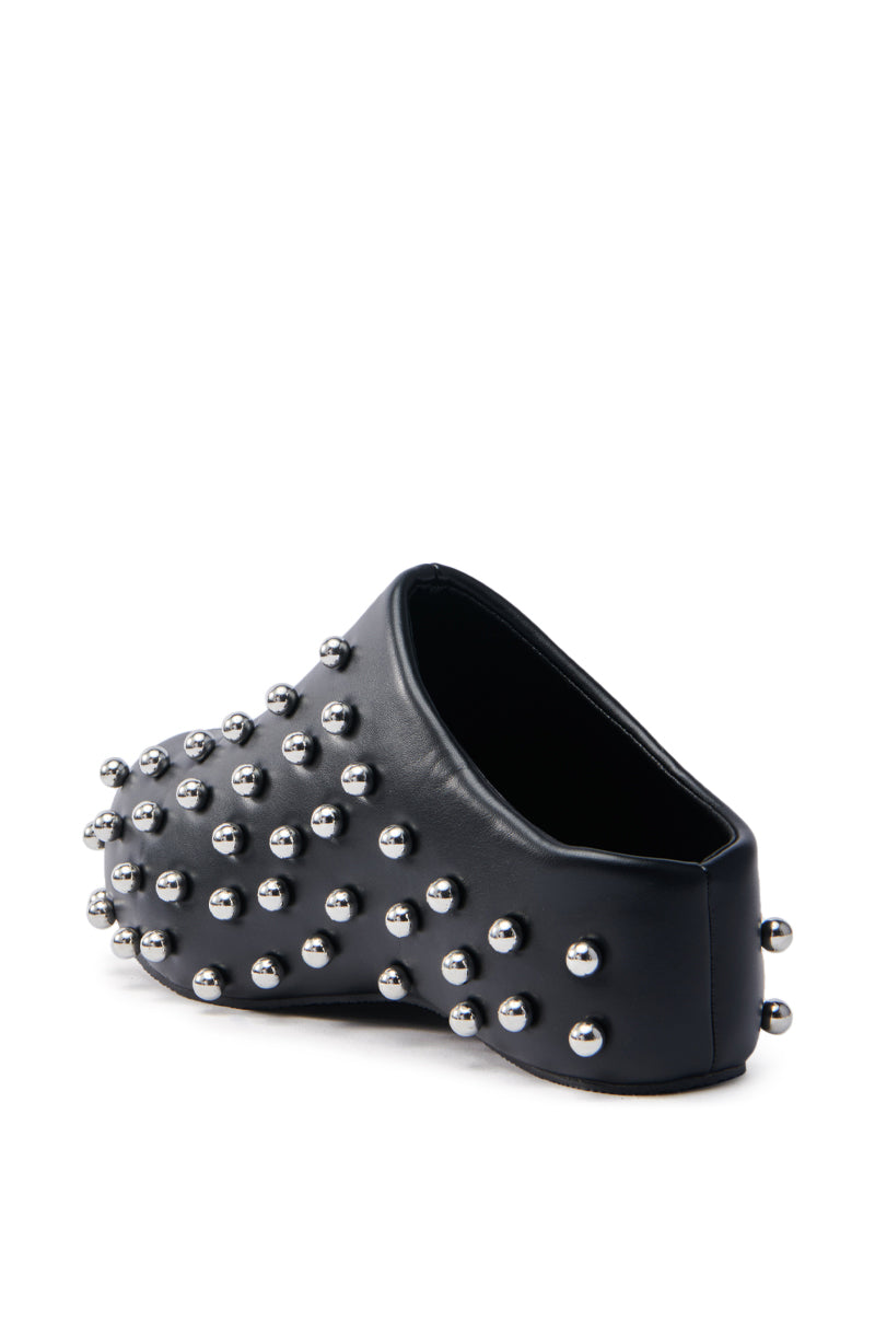 The AZALEA WANG DARWIN STUD FLAT CLOG IN BLACK features a chunky heel and closed toe crafted from vegan leather, embellished with metallic silver studs. Its edgy, bold look stands out against a plain white background.
