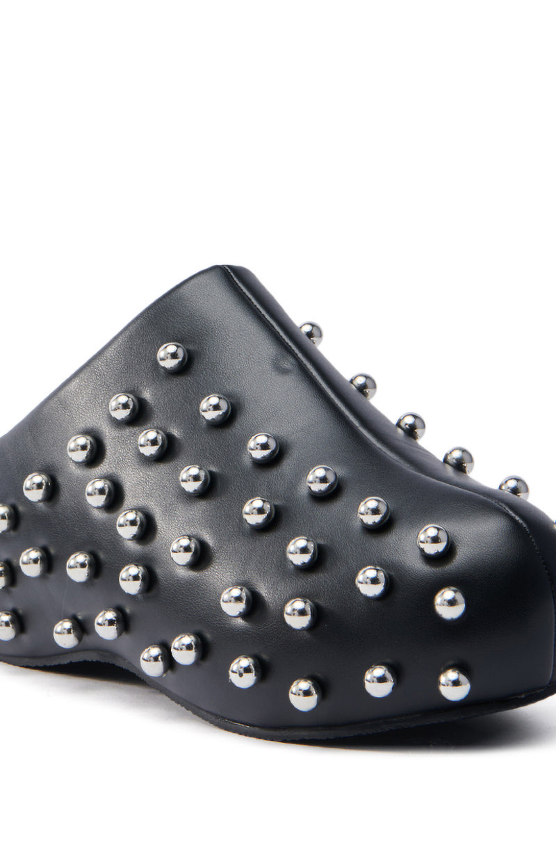 The AZALEA WANG DARWIN STUD FLAT CLOG IN BLACK features a sleek vegan leather design adorned with evenly spaced metallic studs. Its modern, edgy style and flatform sole create a striking look, while the shiny round studs reflect light beautifully.