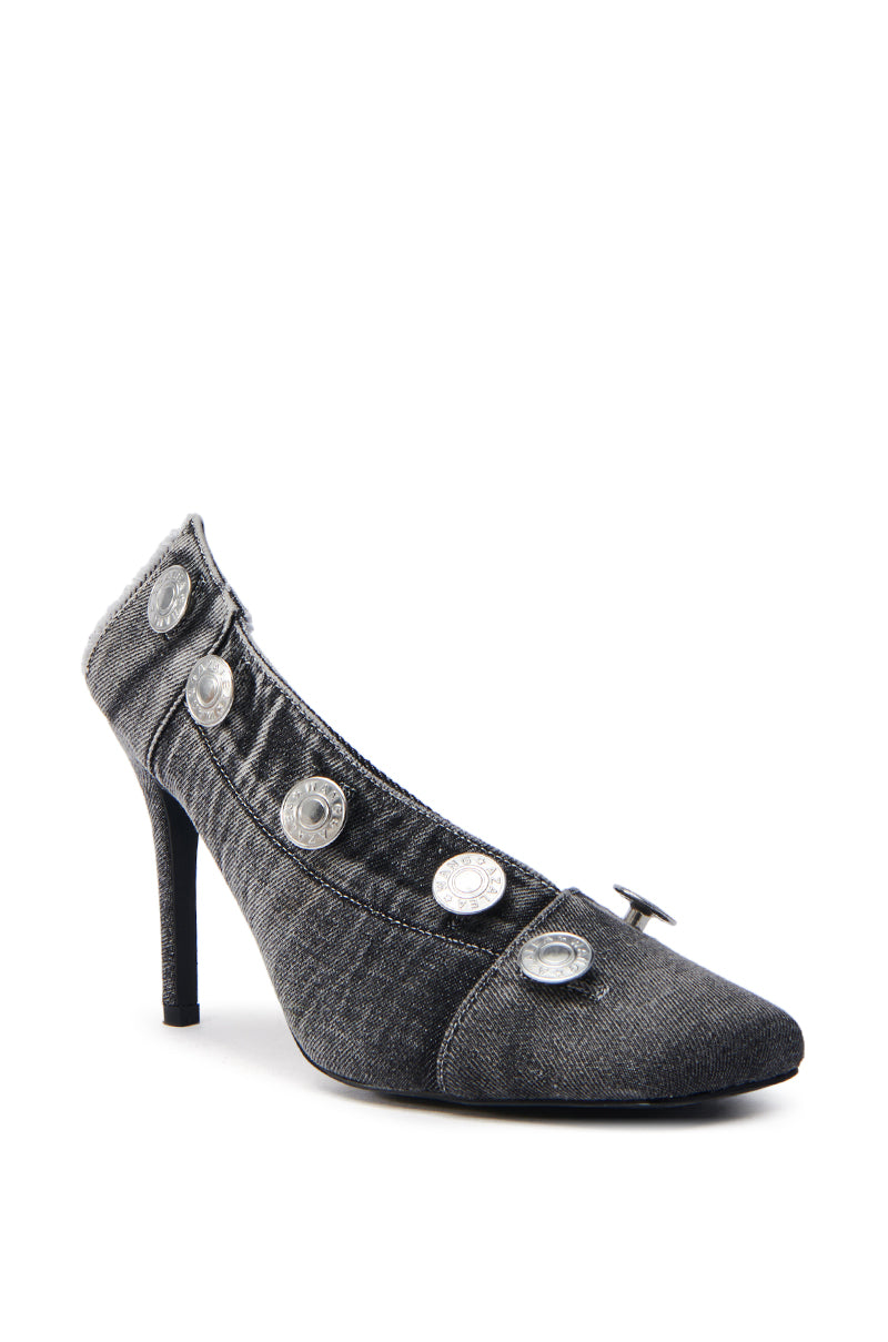 The AZALEA WANG EBRIMA DENIM STILETTO PUMP features a pointed toe and slim heel, adorned with metallic buttons along the side, creating a trendy and stylish look perfect for any fashionable occasion.