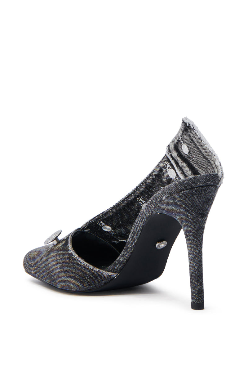 The AZALEA WANG EBRIMA DENIM STILETTO PUMP is a gray, pointed-toe stiletto featuring textured fabric and decorative button accents along the opening. It boasts a sleek black sole with a tall, slender heel for added height and elegance.