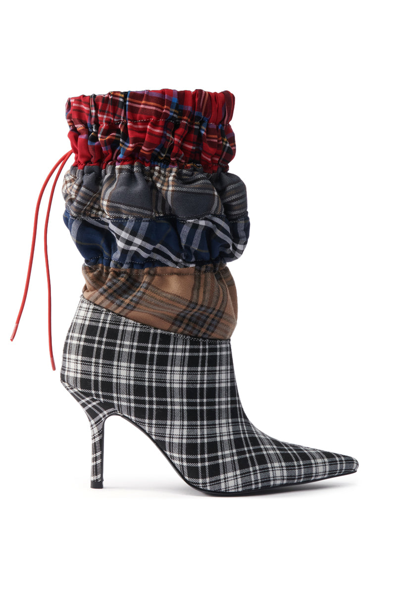 The AZALEA WANG ELADIES MULTI BOXER BOOTIE features a stiletto heel, pointed toe, black-and-white plaid on the lower part, and layered ruched tartan fabric in red, blue, and brown around the ankle and calf.