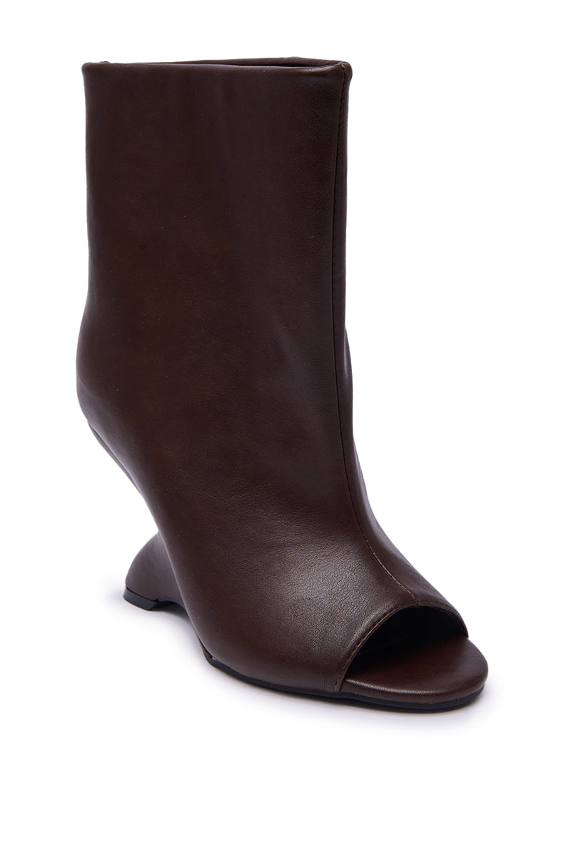 The AZALEA WANG FAOI Brown Inverted Wedge Open-Toe Bootie features a sculptural curved high heel, peep toe, and smooth leather construction.