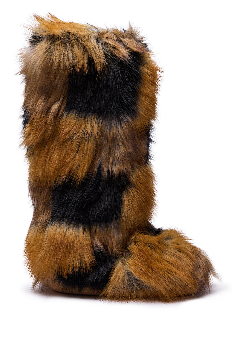 The AZALEA WANG FENNEC MULTI PATCH WORK FUR KNEE HIGH BOOT is a tall boot featuring thick, shaggy faux fur in mixed brown and black patches, resembling animal fur, shown against a plain white background.