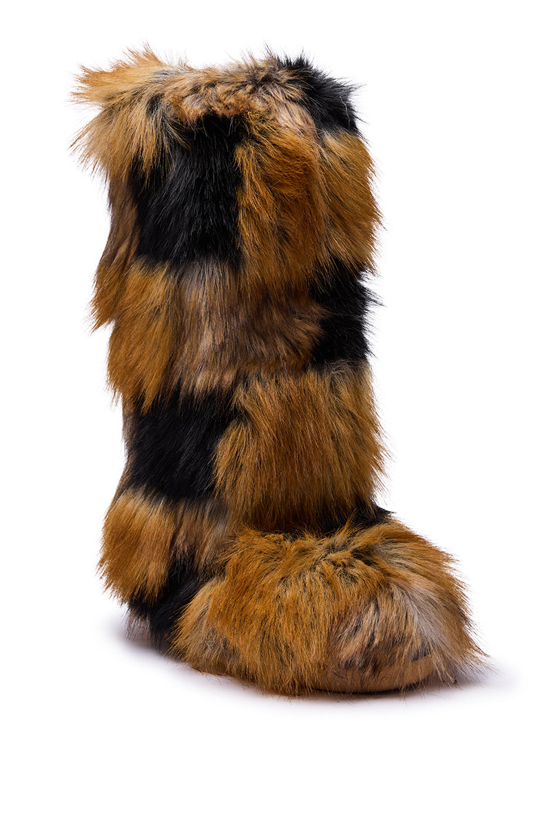 The AZALEA WANG FENNEC MULTI PATCH WORK FUR KNEE HIGH BOOT features tall, knee-high construction with shaggy multicolored faux fur in brown, tan, and black patches, a rounded toe, and a thick, fluffy texture resembling animal fur.