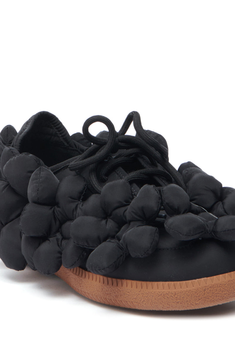 The AZALEA WANG GREYI BLACK PUFF FLORAL FLAT SNEAKER showcases puffy, bubble-like textile floral clusters on the sides and upper, black laces, and a brown rubber sole for bold style.