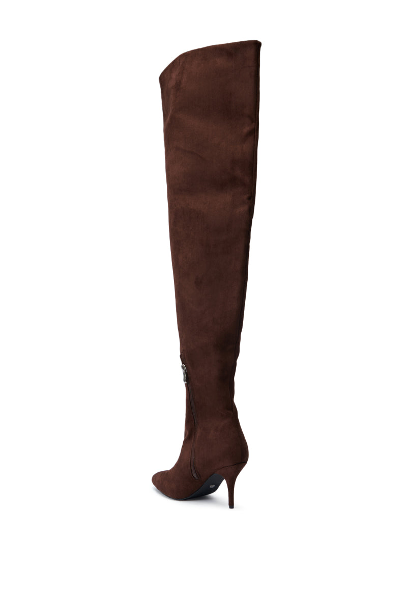 The AZALEA WANG HALINA BROWN FAUX SUEDE STILETTO BOOT, highlighted by its pointed toe and high heel, is elegantly displayed against a white background with its sleek side zipper.