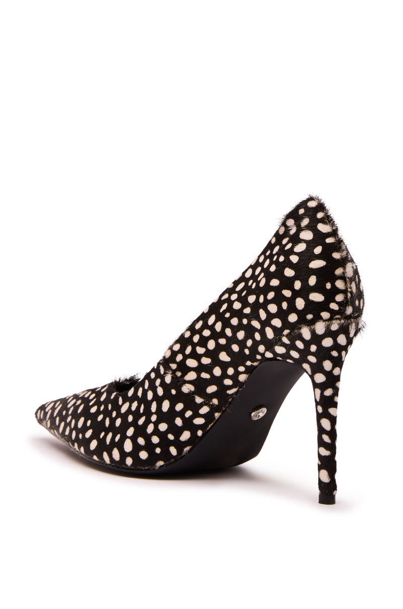 The AZALEA WANG HALL BLACK MULTI SPOTTED PONY HAIR PUMP is a high-heeled, pointed toe shoe with a black base, white polka dots, slender stiletto heel, and textured pony hair material, shown from the back side angle.