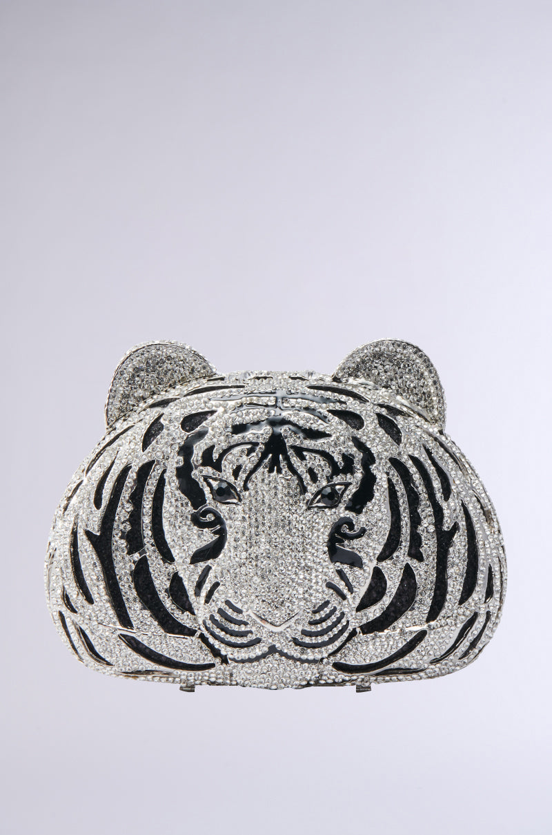 The HEAR ME ROAR BLING BAG is a dazzling, crystal-studded tiger-faced clutch with black and silver details, round ears, and intricate stripes—its rhinestones sparkle brilliantly against a plain light background.