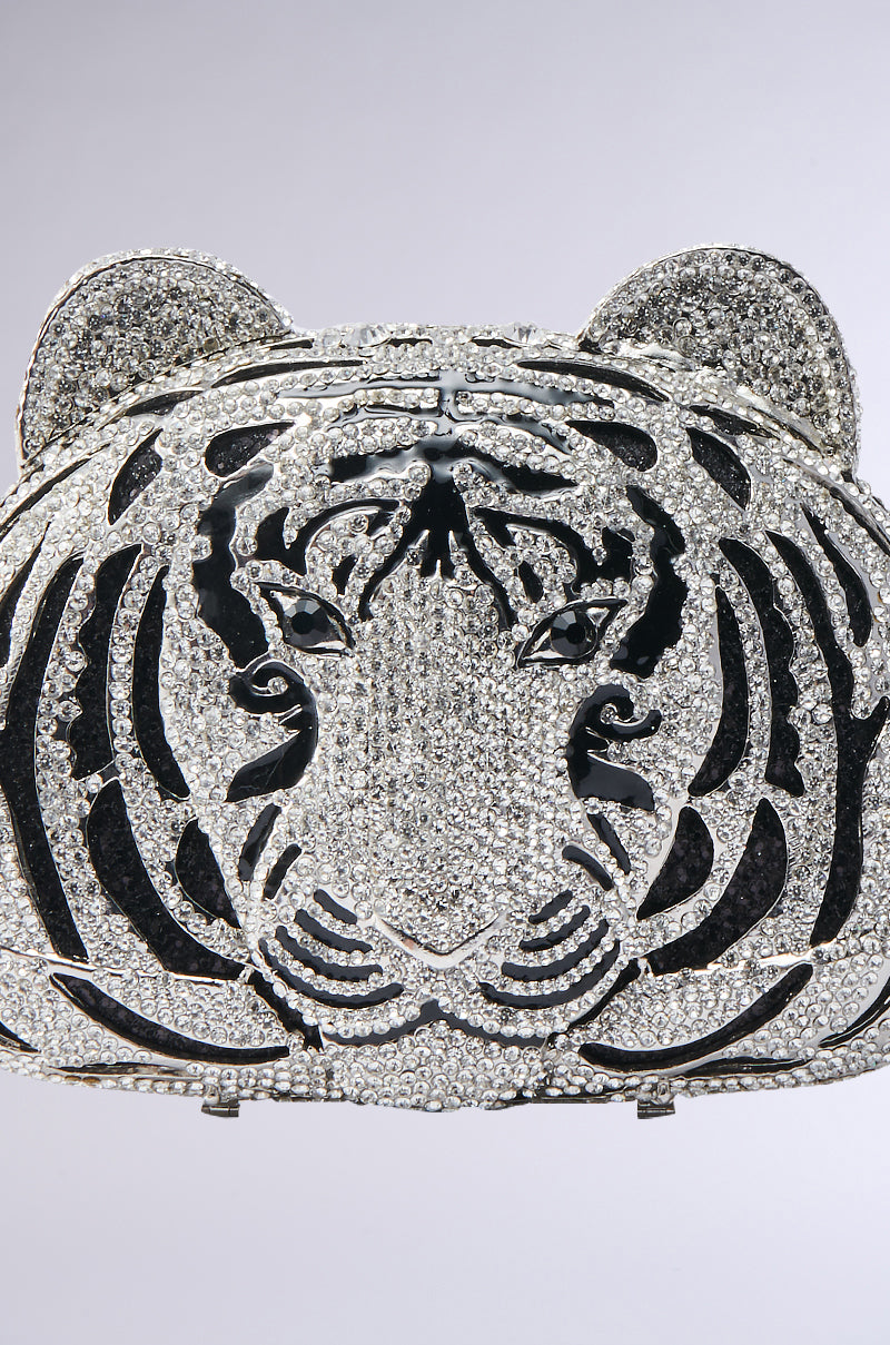 A close-up of the HEAR ME ROAR BLING BAG, a sparkling clutch shaped like a tiger’s face with rhinestone stripes and ears, set against a plain light background—a dazzling statement piece for any occasion.