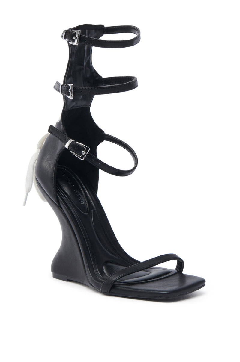 The AZALEA WANG ISAAK black wedge sandal has a striking sculpted design in faux leather, with three buckled ankle straps and a thin toe strap. Its sleek style features an open square toe and a high arch, combining elegance with modern flair.