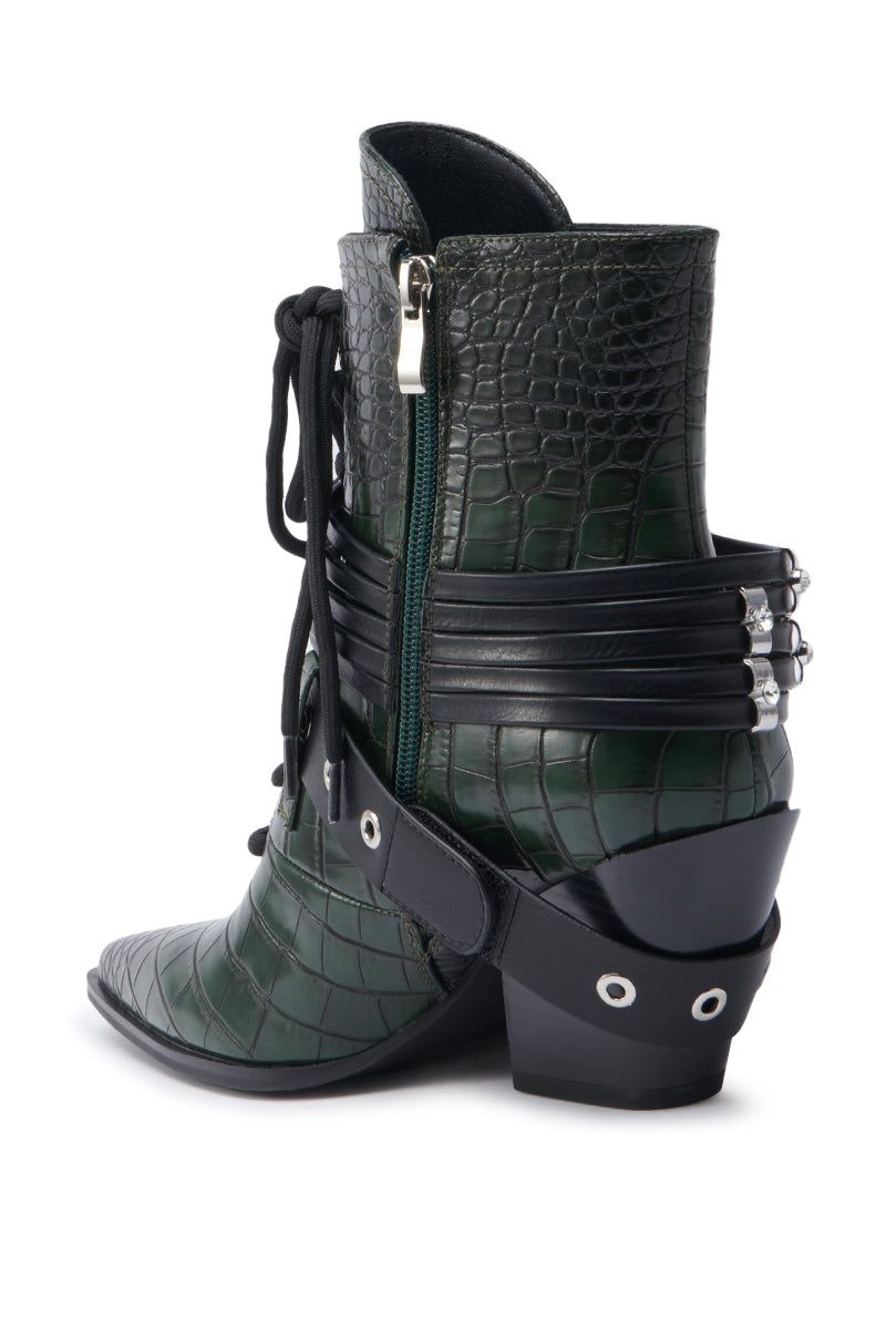 The AZALEA WANG JAVELIN GREEN WESTERN BOOTIE features a dark green crocodile-embossed finish, side zipper, buckled heel straps, pointed toe, chunky angled heel, and decorative eyelet details near the back.