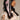 A person with long dark hair in profile adorned with the CUTESY HAIR CLIP SET: pink satin bows and a delicate barrette. They're wearing a white crocheted top with intricate designs and a pink garment featuring fabric bows and lace, all highlighted against a neutral background.