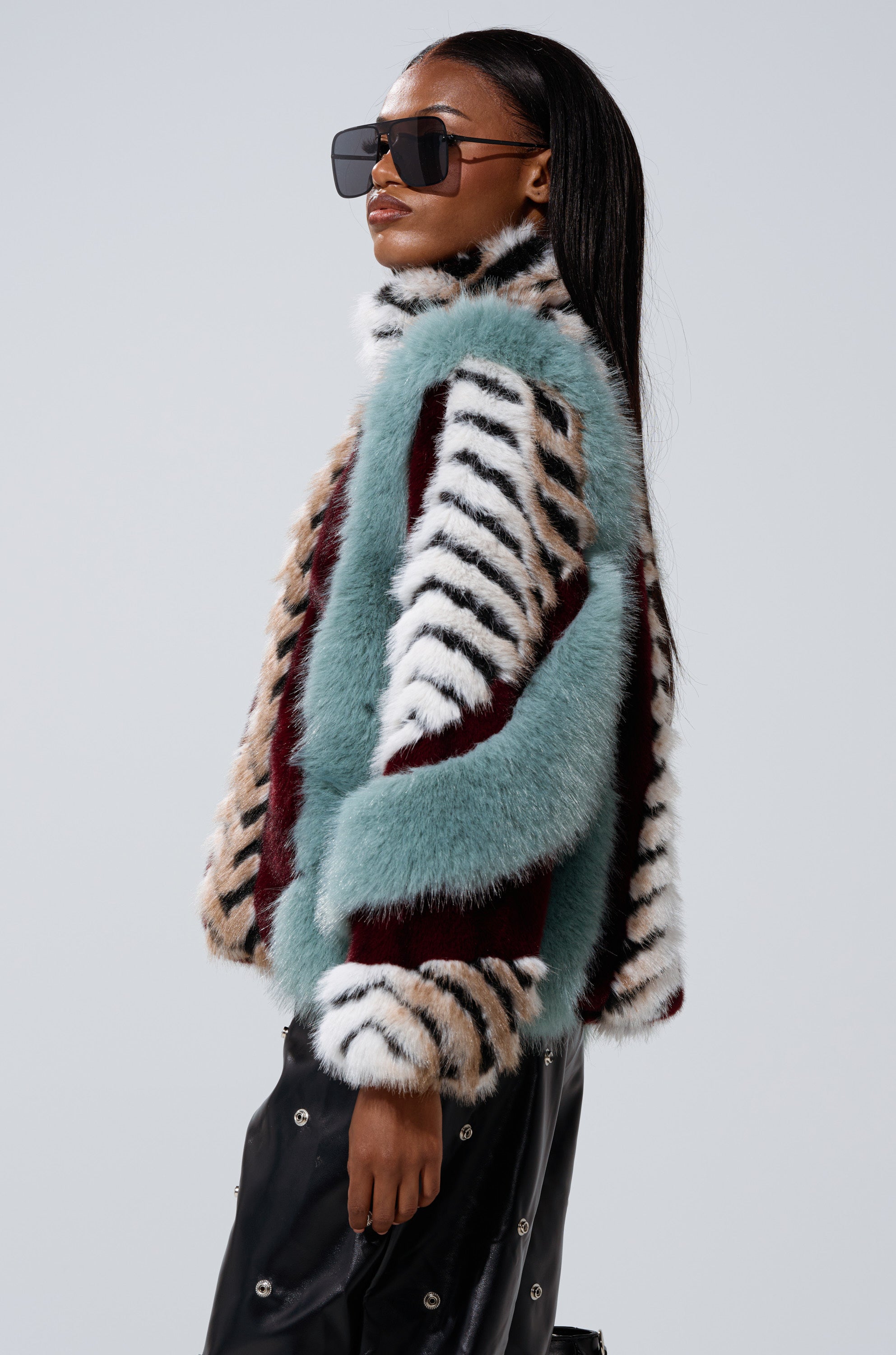 A woman in the HAVE IT ALL PANELED FUR COAT exudes effortless style.