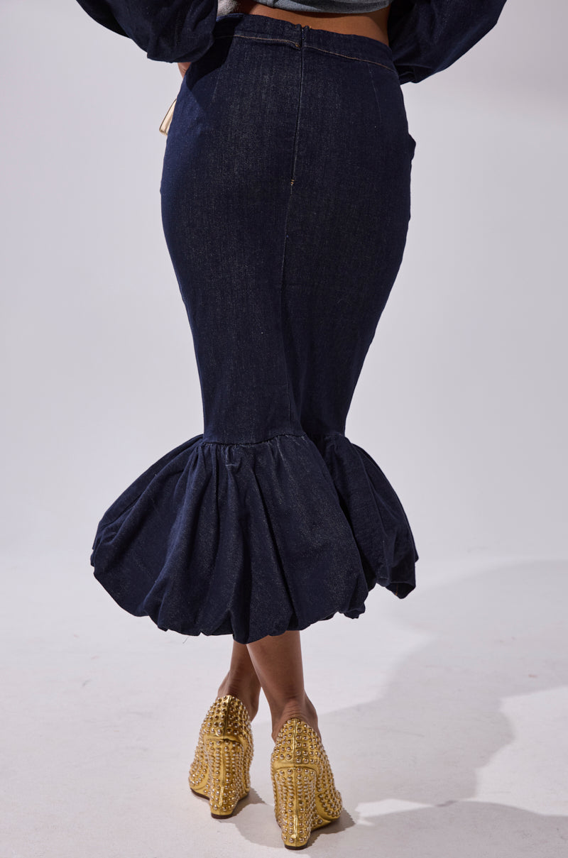 A person wearing the LET'S CHANGE IT UP DENIM MIDI SKIRT and gold textured high heels, shown from the back against a plain white background.