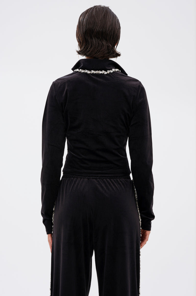 A person with short dark hair faces away from the camera, wearing the DARA RHINESTONE MOCK NECK ZIP-UP SWEATSHIRT with a jeweled collar, paired with matching pants, set against a plain white background.