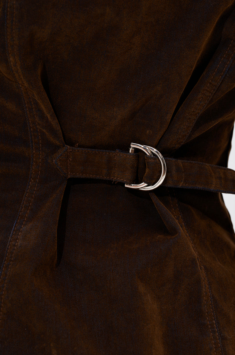 A close-up of the FALL VIBES VELVET DENIM BUTTON DOWN features rich velvet texture and fine stitching, accented by a belt threaded through a silver D-ring buckle—ideal for effortless fall layering with your favorite oversized shirt.