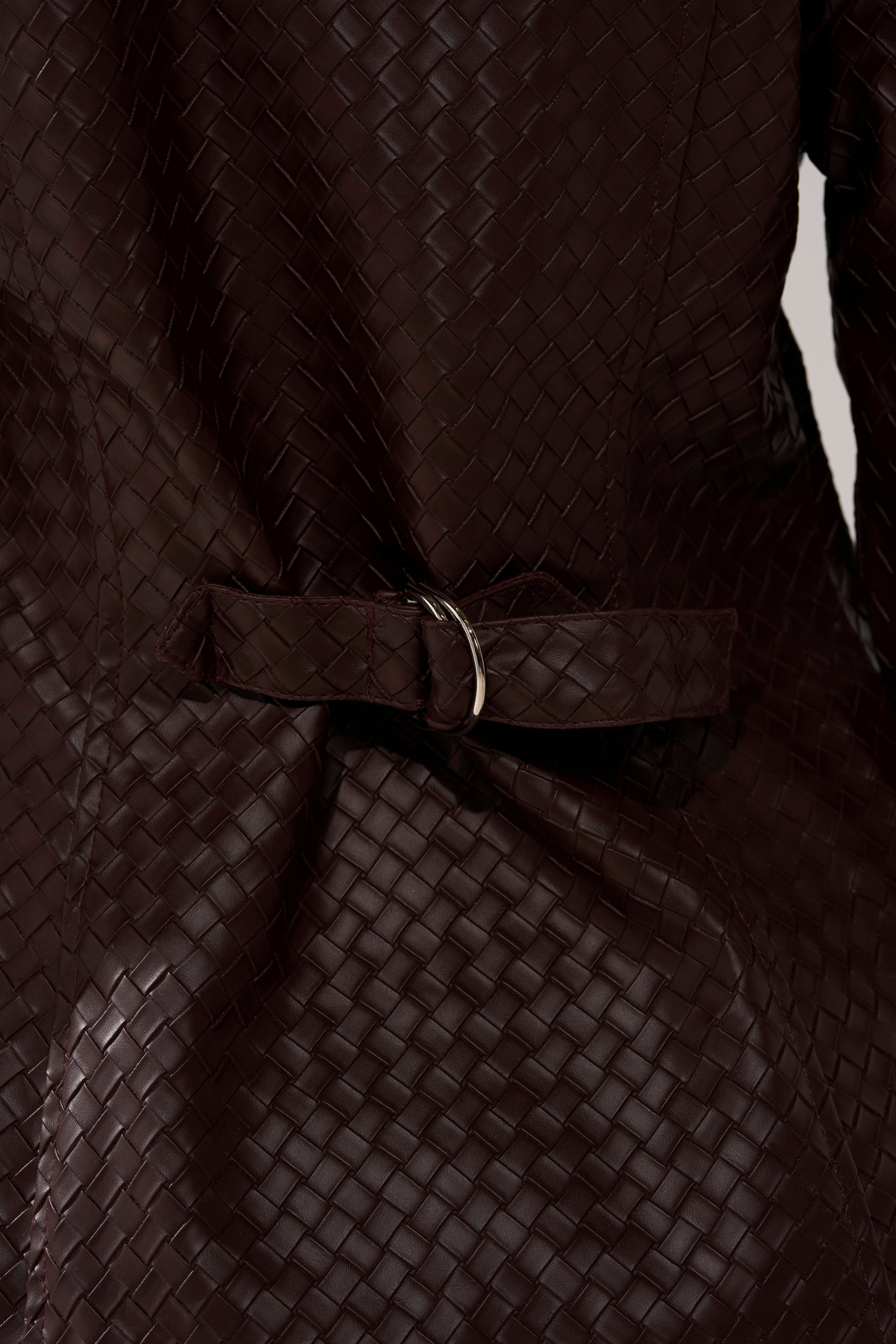 Close-up of the FEELING RICH FAUX LEATHER BUTTON DOWN, featuring a dark brown woven texture and a matching adjustable belt with a silver ring buckle.