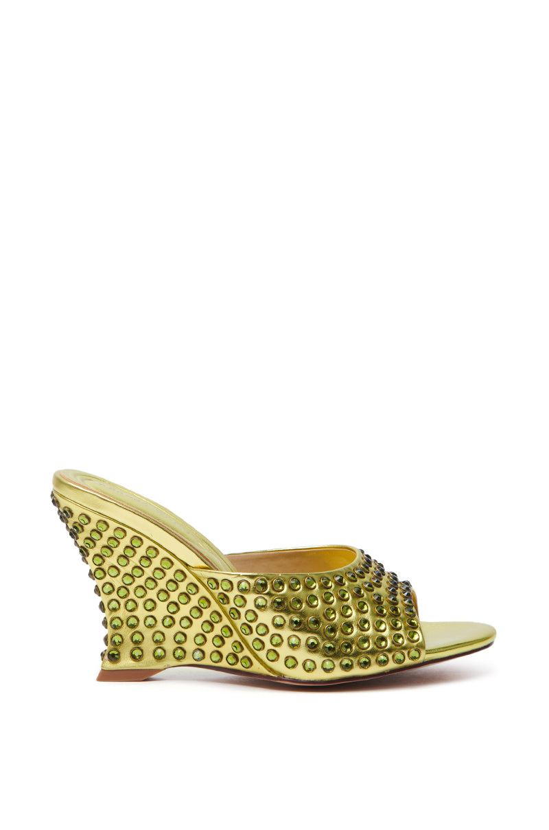 The AZALEA WANG JUNIUS sandal is a lime green faux leather wedge with round studs, an open toe, a textured surface, and studded detailing on the heel and front strap. It includes a comfort cushion insole for added comfort.