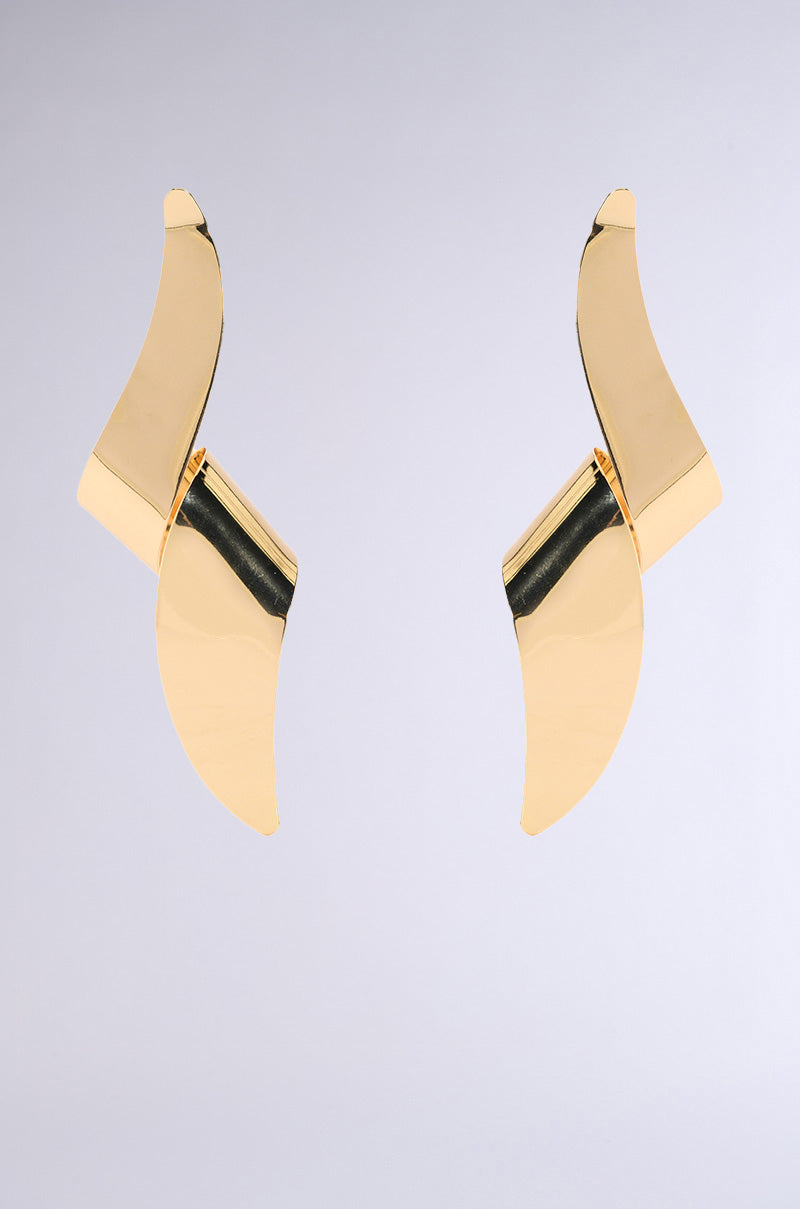 Two TWISTED UP EARRINGS with asymmetrical silhouettes and curving shapes lie on a light gray background, featuring sleek, reflective surfaces in faux metallic gold for a modern and elegant look.