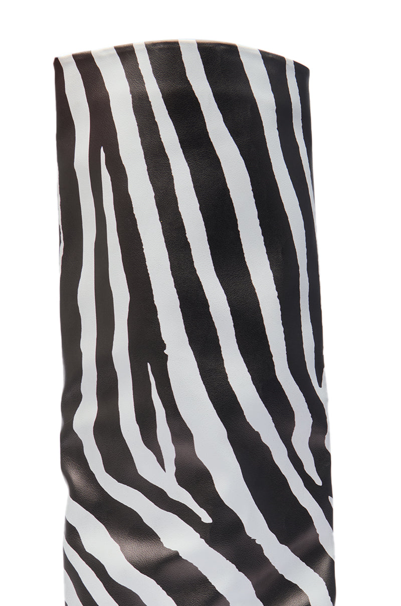 A close-up of the AZALEA WANG KENYA ZEBRA KNEE HIGH WEDGE BOOT, featuring a bold black and white zebra stripe pattern, shown against a white background.