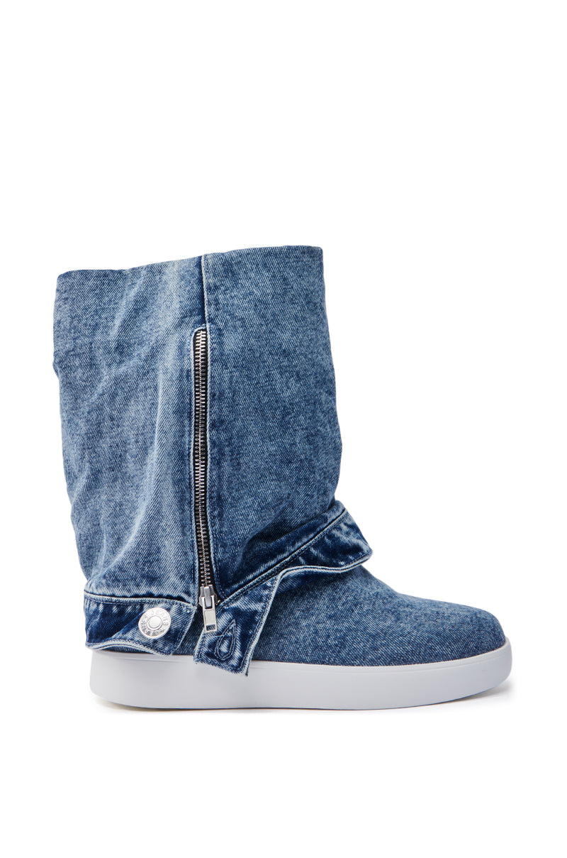 Side view of the AZALEA WANG KIMIKA DENIM BOOTIE: a blue denim bootie with a slouchy design, zipper detail, flat white sole, mid-calf shaft with a folded upper section, and silver buttons near the ankle.